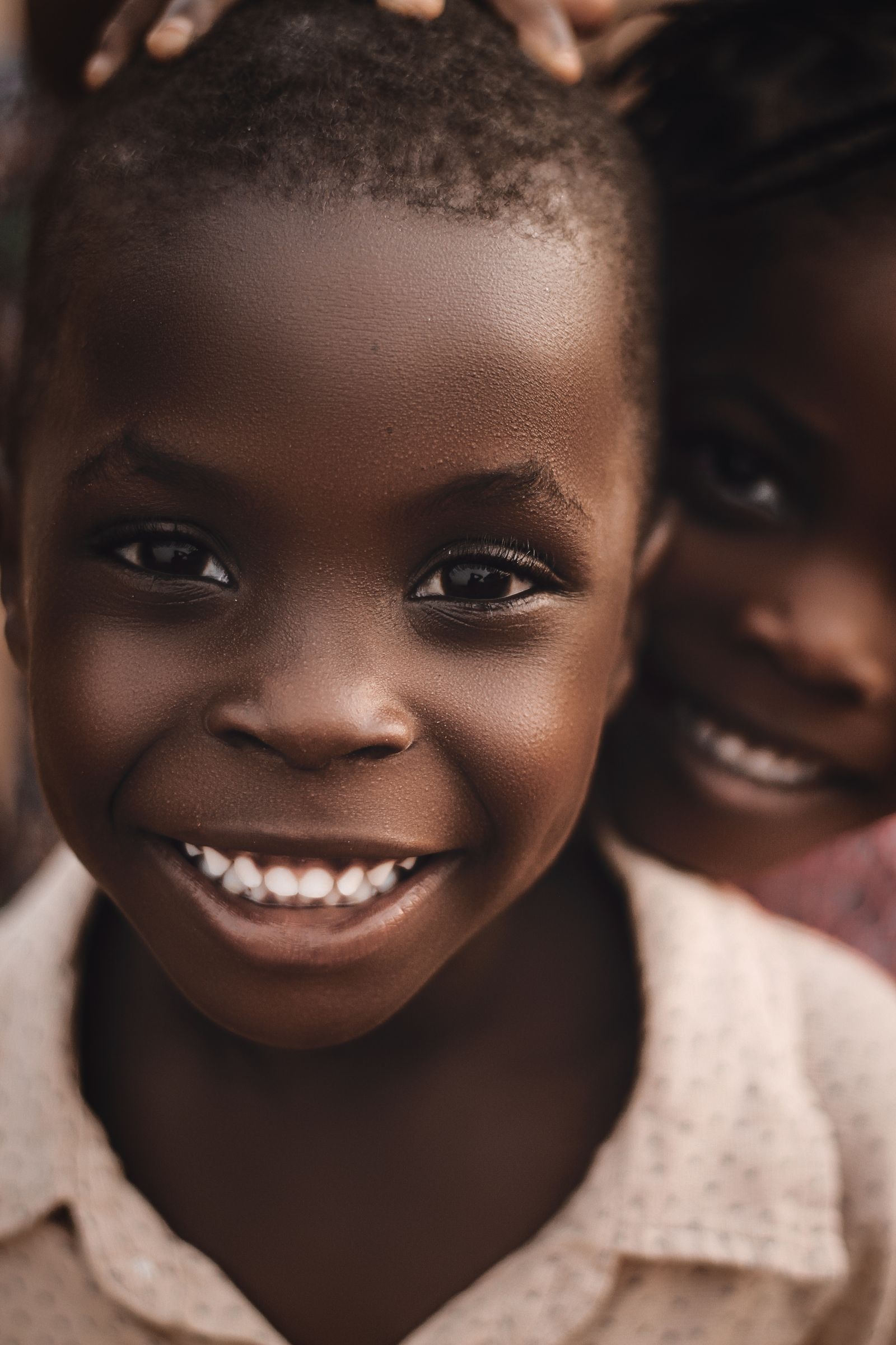 A smiling child looks straight into the camera.